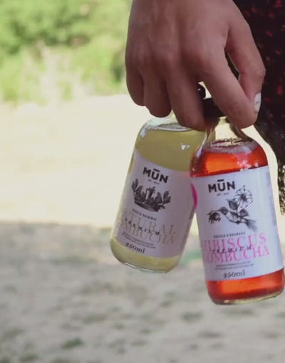 Persona caminando con dos botellas de kombucha Mūn